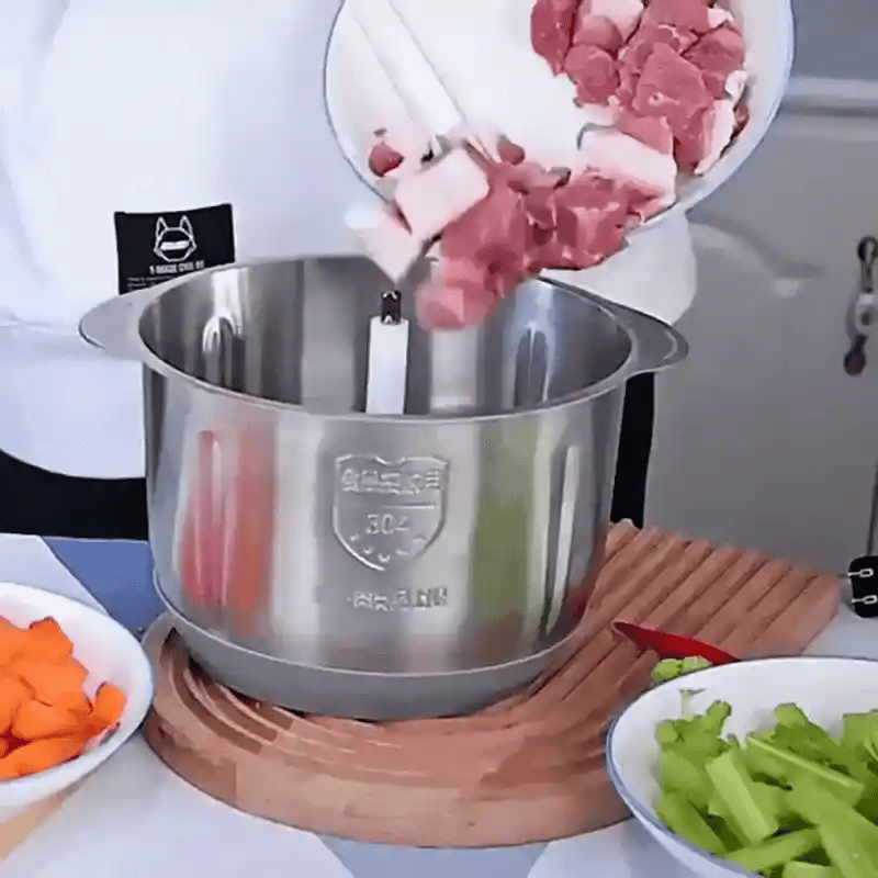 Procesador triturando verduras en la encimera de la cocina